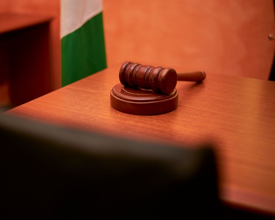 A wooden judicial gavel resting on a courtroom desk, symbolizing the Schedule I legal classification of ibogaine.